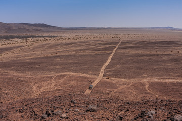 An aerial view of a single SUV on the Harrat Kishb volcanic field, Makkah Province, Saudi Arabia