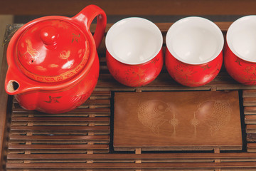 Chinese tea ceremony, Puer in assortment, Ceramic brown teapot for brewing tea and a bowl with raw materials on a bamboo table	