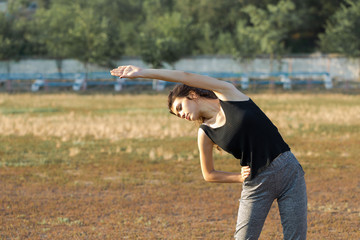 A young slim athletic girl in sportswear performs a set of exercises. Fitness and healthy...