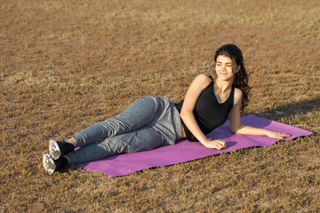 A young slim athletic girl in sportswear with snakeskin prints performs a set of exercises. Fitness...