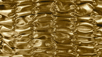 Golden  shirred background. Metallic shiny material. Detail, background. Close up, texture,