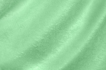 Trendy neo mint colored background of soft draped fabric. Beautiful velvet textured cloth for making clothes and curtains. Textile background texture. Color of the year 2020
