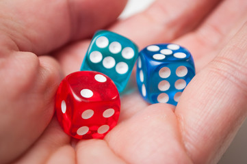 Closeup of colorful dices in hand on white background