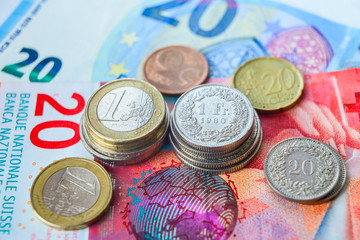 banconote e monete di euro e franchi svizzeri