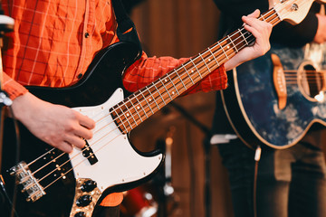 Obraz na płótnie Canvas Guy playing bass guitar in a band. Fragment