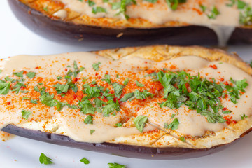 Oven roasted eggplant with vegan tahini sauce, ghost pepper powder and parsley