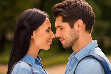 Profile photo of amazing pair going to kiss contacting noses closing eyes wear denim outfit
