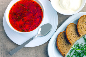 On the table is a plate with soup borsch,the main first dish of the Eastern Slavs sour cream and slices of bread