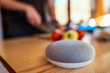 Smart ai speaker. Smart home concept with woman cooking in the background