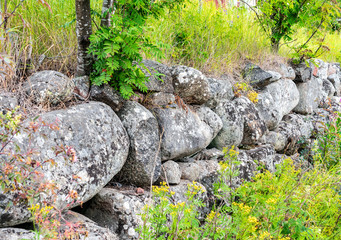 Round stones wall - typical swedish countryside, sweden landscape north, summer.