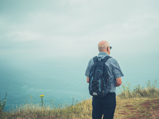 Senior man looking at the sea on foggy day