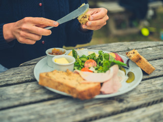Woman buttering bread at picnic table