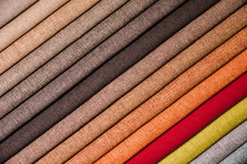 Colorful and bright fabric samples of furniture and clothing upholstery. Close-up of a palette of textile abstract stripes of different colors