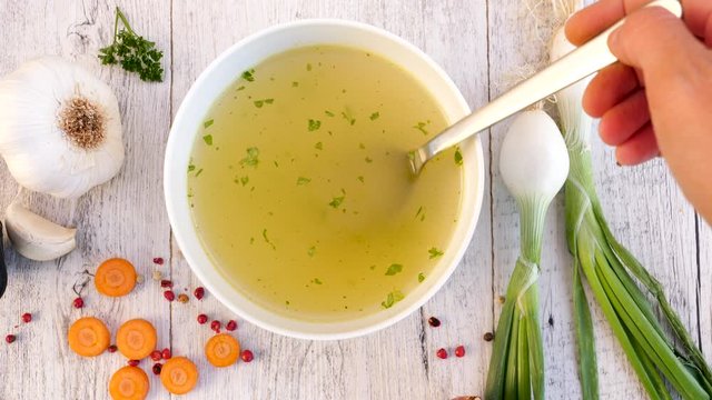 vegetable broth in bowl with woman hand