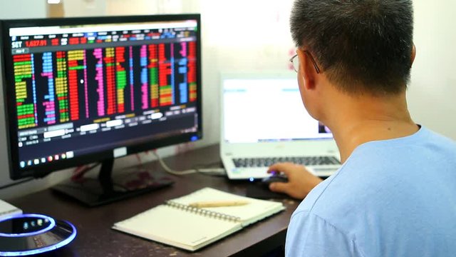 Trader or broker  monitoring  stock exchange from monitor  , Chiangmai Thailand