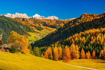 Autumb scenery with mountain hills and yellow trees illuminated by sun. Alta Badia, Dolomite Alps, Italy