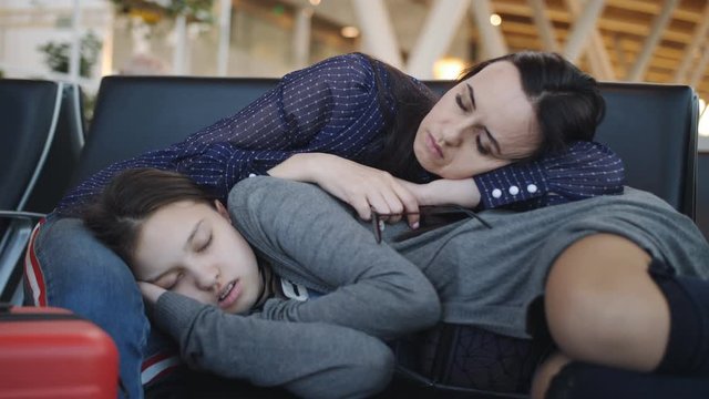 A woman with a teenage daughter in the airport lounge sleep from exhaustion. The cancellation of the flight.