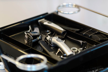 Hair clipper and scissors on a black table.