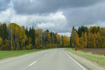 Autumn scene with winding asphalt road in the countryside. 