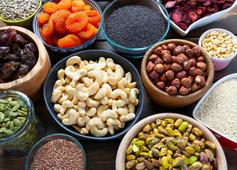 nuts, seeds and dried fruis on wooden surface