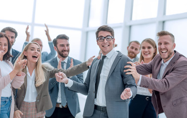 Obraz premium happy young businessman standing in front of his business team.