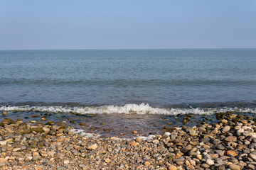 Seascape with a small wave in the summer morning hours.