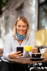 Young woman using smartphone in cafe