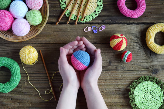Making colored crochet balls. Toy for babies and toddlers to learn mechanical skills and colors. On the table threads, needles, hook, cotton yarn. Handmade crafts. DIY concept.