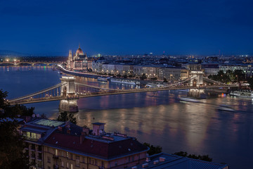 Fototapeta na wymiar Budapest, Hungary - Aerial skyline view of Budapest with the famous illuminated Szechenyi Chain Bridge and Hungarian Parliament building at blue hour with sightseeing boats on River Danube