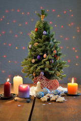 Christmas tree with the gingerbread Santa and horse, candles, ornate eggs on the table