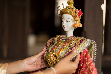 Close up hand of Asian woman holding The "Sita" Traditional Thai style puppet dolls with elegant costume. People or Traditional Thai Puppet Theater of Arts and culture concept.