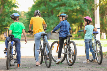 Naklejka premium Cute children riding bicycles outdoors