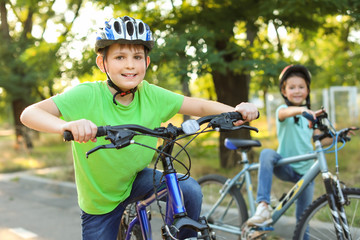 Naklejka premium Cute children riding bicycles outdoors