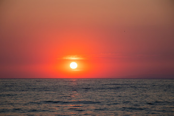 Sunset at sea during a beautiful golden hour. Landscape of the sun setting on the horizon.