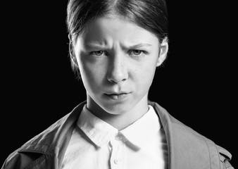 Black and white portrait of angry little girl on dark background