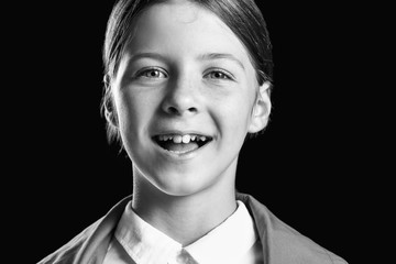 Black and white portrait of cute little girl on dark background