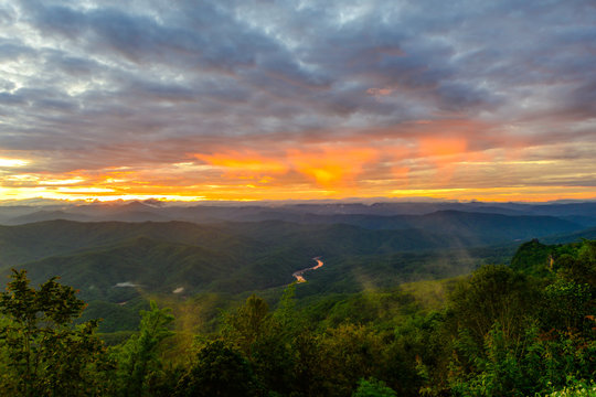 senery view of peak top mountain at sunrise with river in bottom view