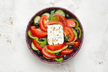 Plate with tasty Greek salad on light background