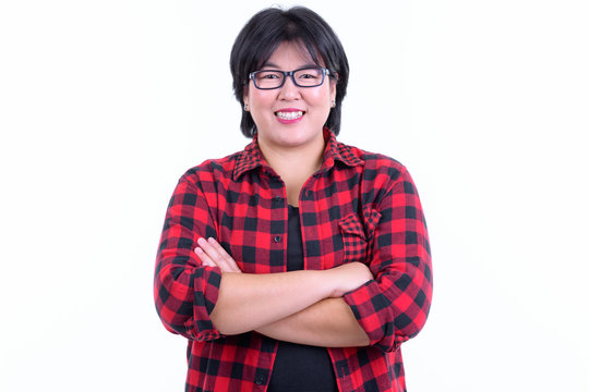Happy overweight Asian hipster woman smiling with arms crossed