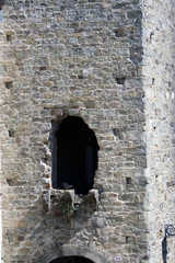 Facciata di torre antica in pietra con finestra