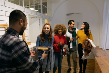Millennial adult friends socialising together at home 