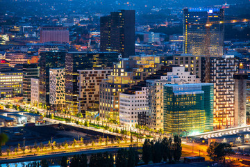 Night view of illuminated street in the Oslo business center. Modern architecture in Norway - obrazy, fototapety, plakaty