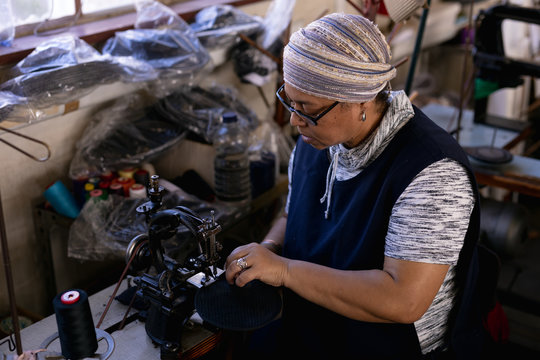 Woman using sewing machine in a hat factory