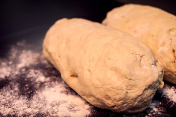 A dough with flour on the black background. Homemade food concept
