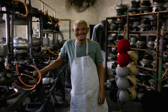 Portrait of man standing in a hat factory 