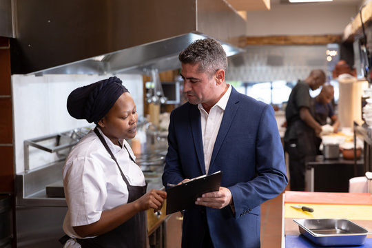 Manager talking to chef in restaurant