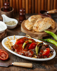Fried meat slices in tomato paste with vegetables