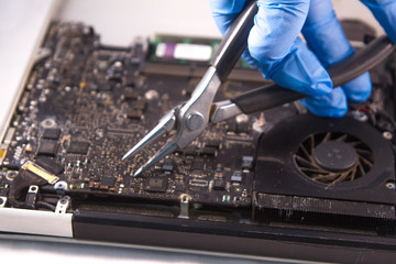 Naklejka premium fixing a hard disk drive with one hand with gloves and a special tweezers