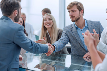 business team applauding the handshake of business partners.