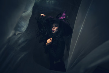 Beautiful young woman in witches hat and costume